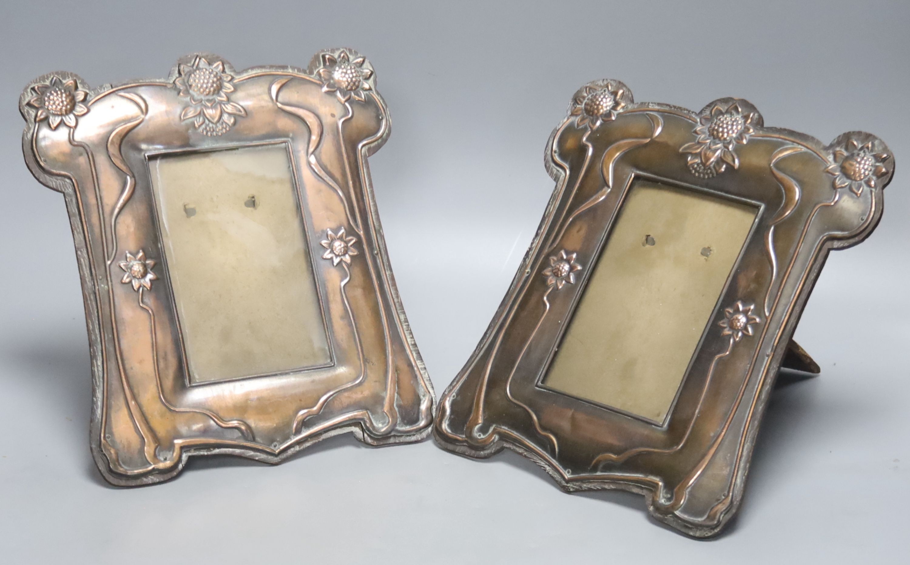 A pair of Art Nouveau embossed copper photograph frames, height 25cm